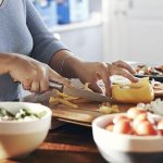 mujer cocina bol con verdura corta pimiento amarillo