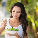 Mujer comiendo un plato saludable de verdura durante la dieta para perder peso