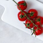 Tomates en rama sobre bandeja blanca