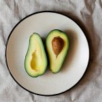propiedades del aguacate cortado en dos sobre plato