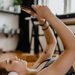 Aplicaciones de ejercicio mujer hace deporte con móvil
